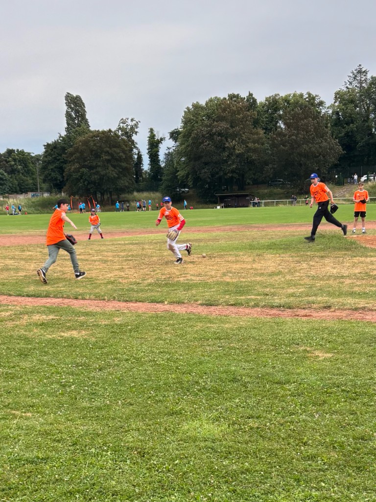 Kinder spielen gemeinsam Baseball auf dem Feld