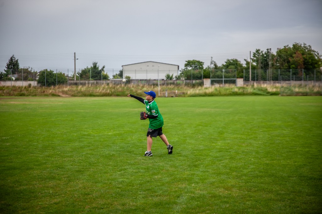 Junge wirft einen Baseball auf dem großen Spielfeld